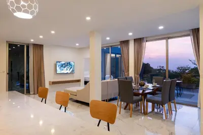 a dining room and living room with a table and chairs at The tree seaview and quiet surrounded by trees 75smetre in Kamala Beach