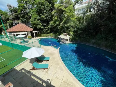 a swimming pool with two chairs and an umbrella at Villa Mauao - Luxury Villa in Katamanda, Kata in Kata Beach