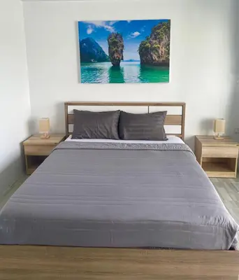 a bedroom with a large bed with two night stands at Apartment Sea View Patong Beach in Patong Beach