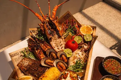 a plate of seafood and vegetables on a table at Phuket Emerald Beach Resort in Karon Beach