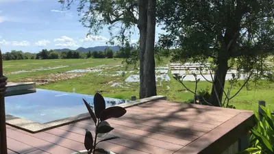 a wooden deck with a view of a field at Rongna Villas in Ko Yao Noi
