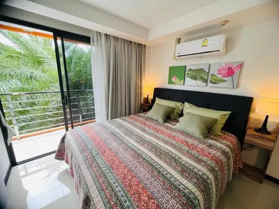 a bedroom with a bed and a large window at Apartments MBC 1308 in Mai Khao Beach