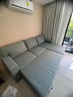 a couch in a living room with a air conditioner at Apartments MBC 1308 in Mai Khao Beach