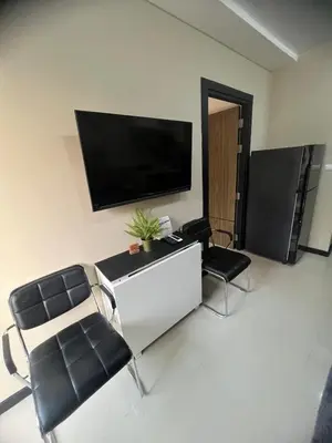 a living room with two chairs and a flat screen tv at Apartments MBC 1308 in Mai Khao Beach