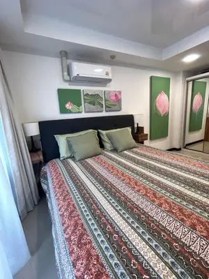 a bedroom with a large bed with a colorful bedspread at Apartments MBC 1308 in Mai Khao Beach