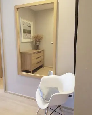 a white chair sitting in front of a mirror at Baan Maikhao pool villa in Mai Khao Beach