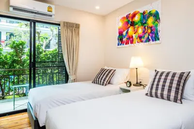 two beds in a room with a window at Direct pool access 2br apartment @The Title Rawai in Rawai Beach