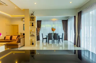 a dining room and living room with a table and chairs at 3 Bedroom Platinum Pool Villa Smooth as Silk in Ban Khlong Haeng