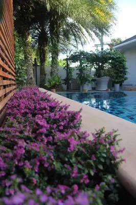 a bunch of purple flowers next to a swimming pool at 3 Bedroom Platinum Pool Villa Smooth as Silk in Ban Khlong Haeng
