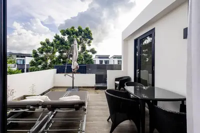 a patio with a glass table and chairs on a balcony at Laguna Park Modern Pool Villa in Phuket Town