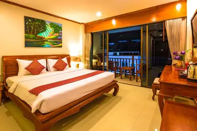 a bedroom with a bed and a desk and a window at Patong Heaven in Patong Beach