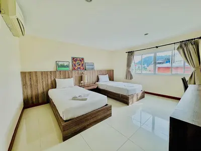 a bedroom with two beds and a window at Cocoon Patong Hotel in Patong Beach