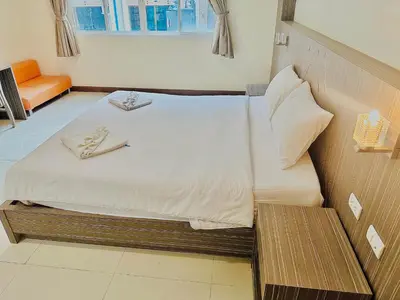 a hotel room with a bed and a bench at Cocoon Patong Hotel in Patong Beach