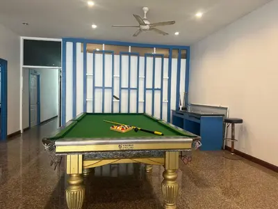 a pool table in a room with a ceiling fan at Cocoon Patong Hotel in Patong Beach