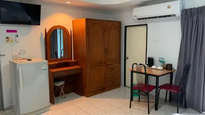 a kitchen with a small table and a refrigerator at Kamalaburi Guesthouse in Kamala Beach