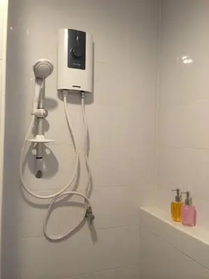 a shower with a blow dryer in a bathroom at Glitter House Phuket in Kata Beach