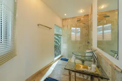 a bathroom with a shower and a glass table at White Villa Patong in Patong Beach