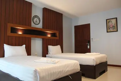 a hotel room with two beds with white sheets at Cokoon Deva Patong Hotel in Patong Beach