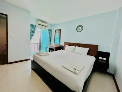 a bedroom with a bed with a clock on the wall at Cokoon Deva Patong Hotel in Patong Beach