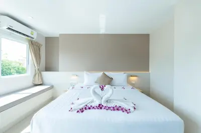 a bedroom with a white bed with a bow on it at La Vista Patong Hotel in Patong Beach