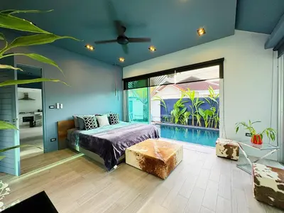 a bedroom with a bed and a swimming pool at Contemporary 3bd Safari Pool Villa Near Nai Yang Beach in Ban Bo Han