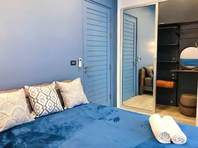 a blue bedroom with a bed and a mirror at Contemporary 3bd Safari Pool Villa Near Nai Yang Beach in Ban Bo Han