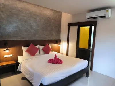 a bedroom with a large bed with red pillows at The Morning mini house aonang - 15-45 years old only in Ao Nang Beach