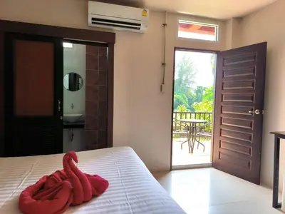 a red towel sitting on a bed in a bedroom at The Morning mini house aonang - 15-45 years old only in Ao Nang Beach