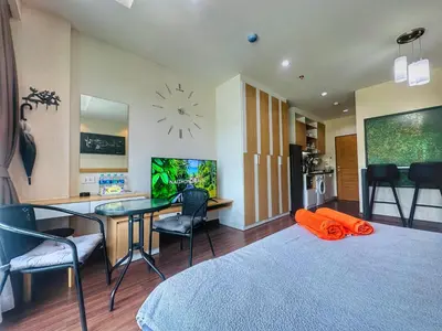 a room with a bed and a desk and a clock at Brand Naithon CondoC404 in Nai Thon Beach