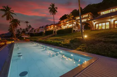 a house with a swimming pool in front of a house at Coconut Grove Resort in Ko Yao Yai