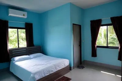 a blue bedroom with a bed and two windows at WS HOUSE KRABI in Ban Ko Kwang