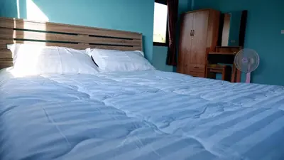 a blue bedroom with a large bed with white pillows at WS HOUSE KRABI in Ban Ko Kwang
