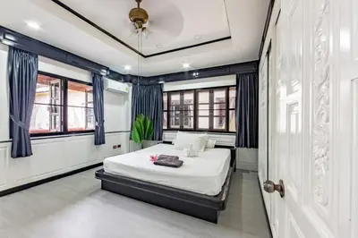 a bedroom with a bed and some windows at Villa Cologne​ @Nanai Villa in Patong Beach