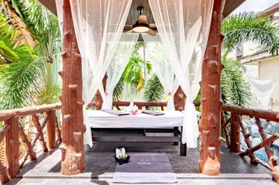 a bedroom with a bed in a room with palm trees at Villa Cologne​ @Nanai Villa in Patong Beach