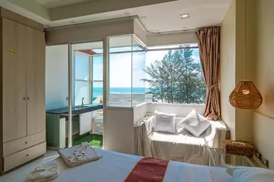a bedroom with a bed and a large window at Catnip Seaside Hotel&Cafe in Ban Huai Luk (1)