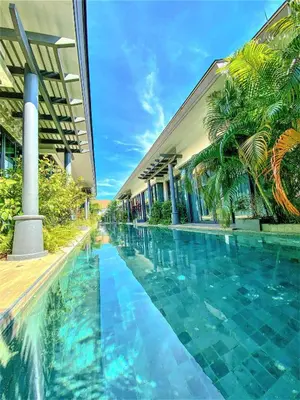 a swimming pool in front of a building at Tajh Pool Villas in Chalong