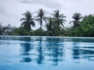 a swimming pool with palm trees in the background at Andaman sea view private in Patong Beach
