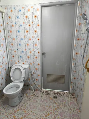 a bathroom with a toilet in front of a door at Nu Phuket Airport Resident 1 in Nai Yang Beach