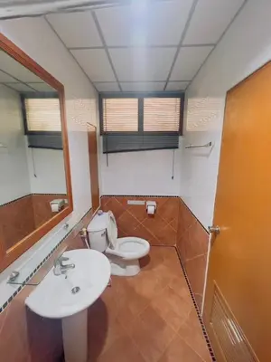 a bathroom with a toilet and a sink and a mirror at Royal Vista Patong in Patong Beach