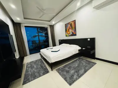 a bedroom with a bed and a large window at Sunrise Villa 21 in Phuket Town