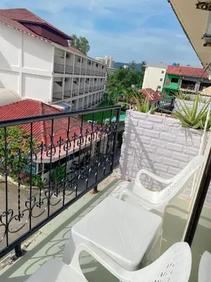a balcony with two white chairs on top of a building at 2 Vikings Guesthouse in Karon Beach