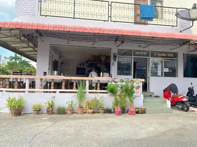 a store with potted plants in front of a building at 2 Vikings Guesthouse in Karon Beach