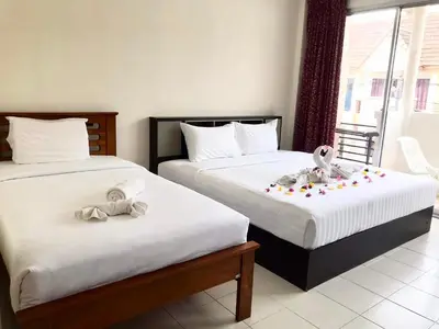 two beds in a hotel room with decorations on them at Kata Beach Guesthouse in Kata Beach
