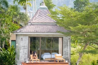 a small cottage with a bed and a window at Anodard Phuket, Nai Yang Beach in Thalang