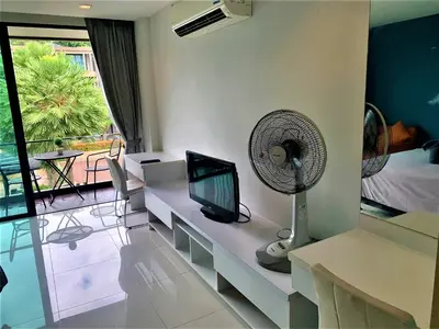 a living room with a television and a fan at Pixel Condo - Panwa Beach in Ban Ao Makham