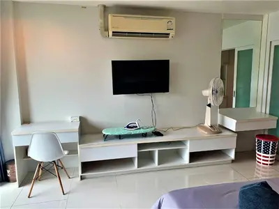 a living room with a tv on a wall at Pixel Condo - Panwa Beach in Ban Ao Makham