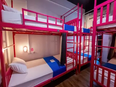 a room with four bunk beds in a room at Slumber Surf Phuket Kata in Kata Beach