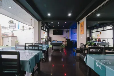 a dining room with tables and chairs in a restaurant at Noble House Patong in Patong Beach