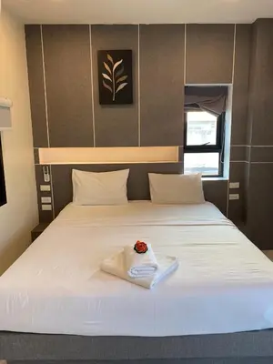 a white bed with a flower on top of it at I AM O'TEL Patong in Patong Beach