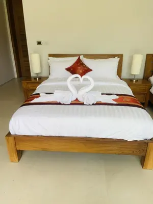 a bed with two white towels on top of it at Villa Jasmine - luxury private villa Bangtao Beach in Bang Tao Beach